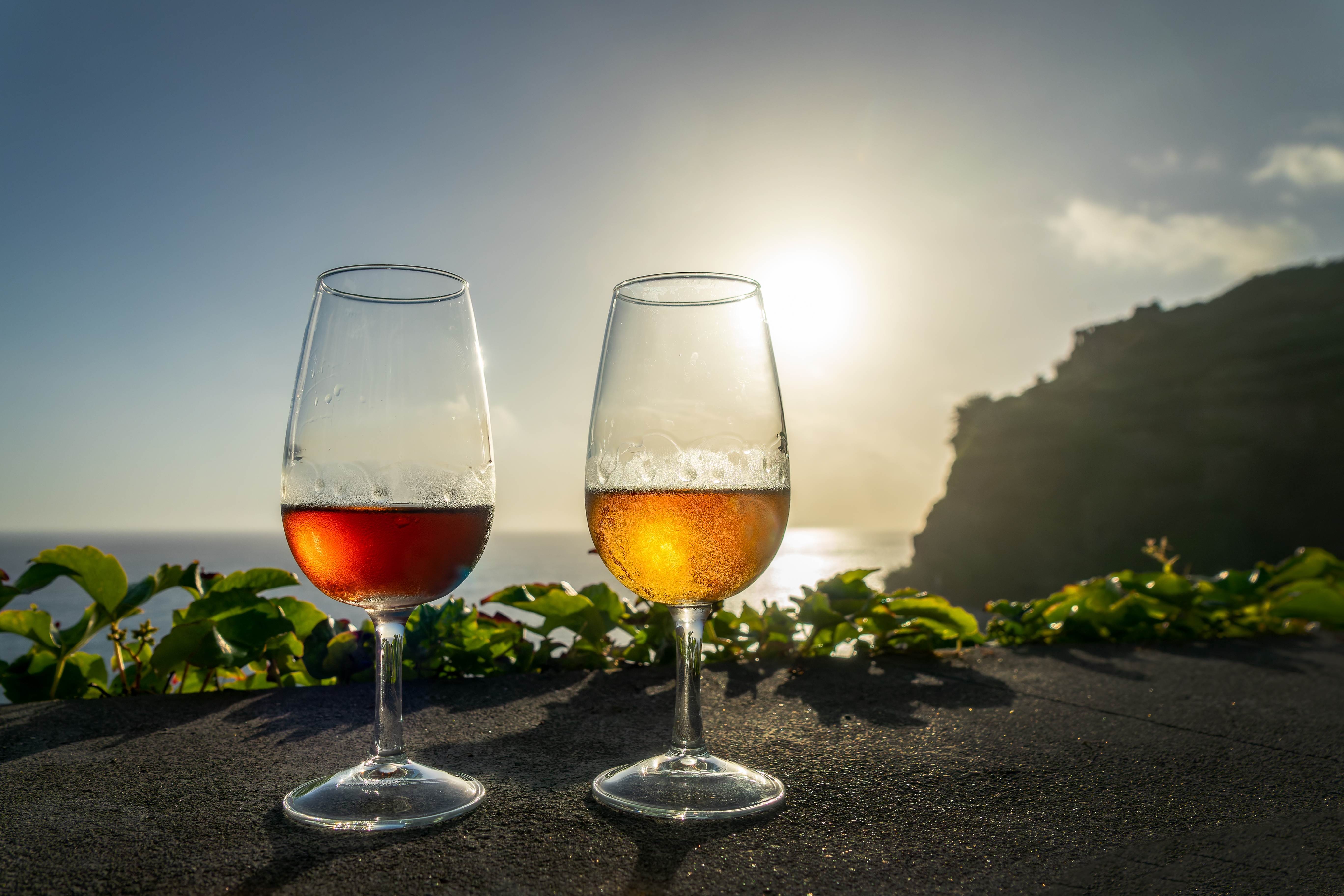 To vinglas med portugisisk vin ved solnedgang med udsigt over Atlanterhavet på Madeira