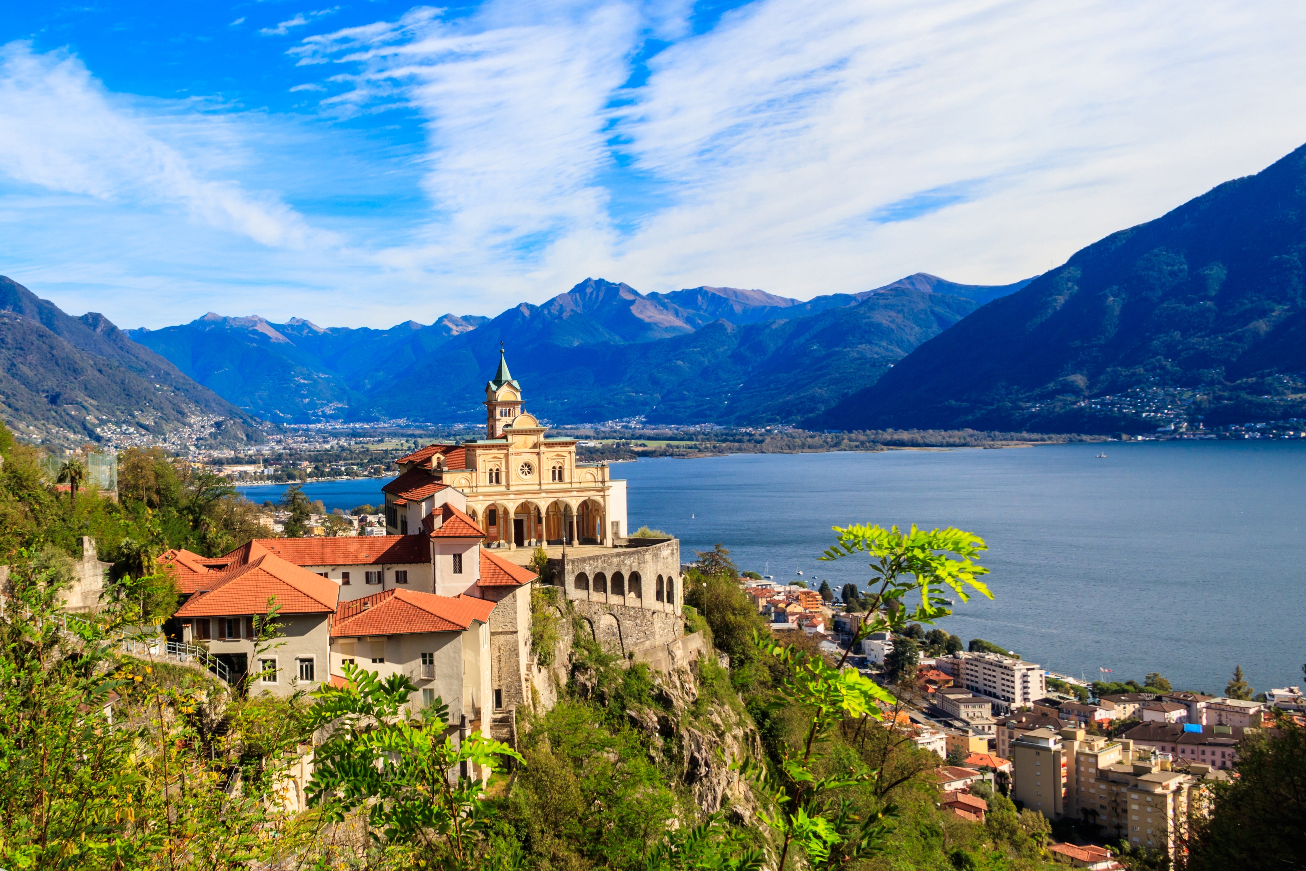 Det historiske Madonna del Sasso kloster på klippen over Maggiore-søen i Locarno, Schweiz med smukke alpebjerge i baggrunden
