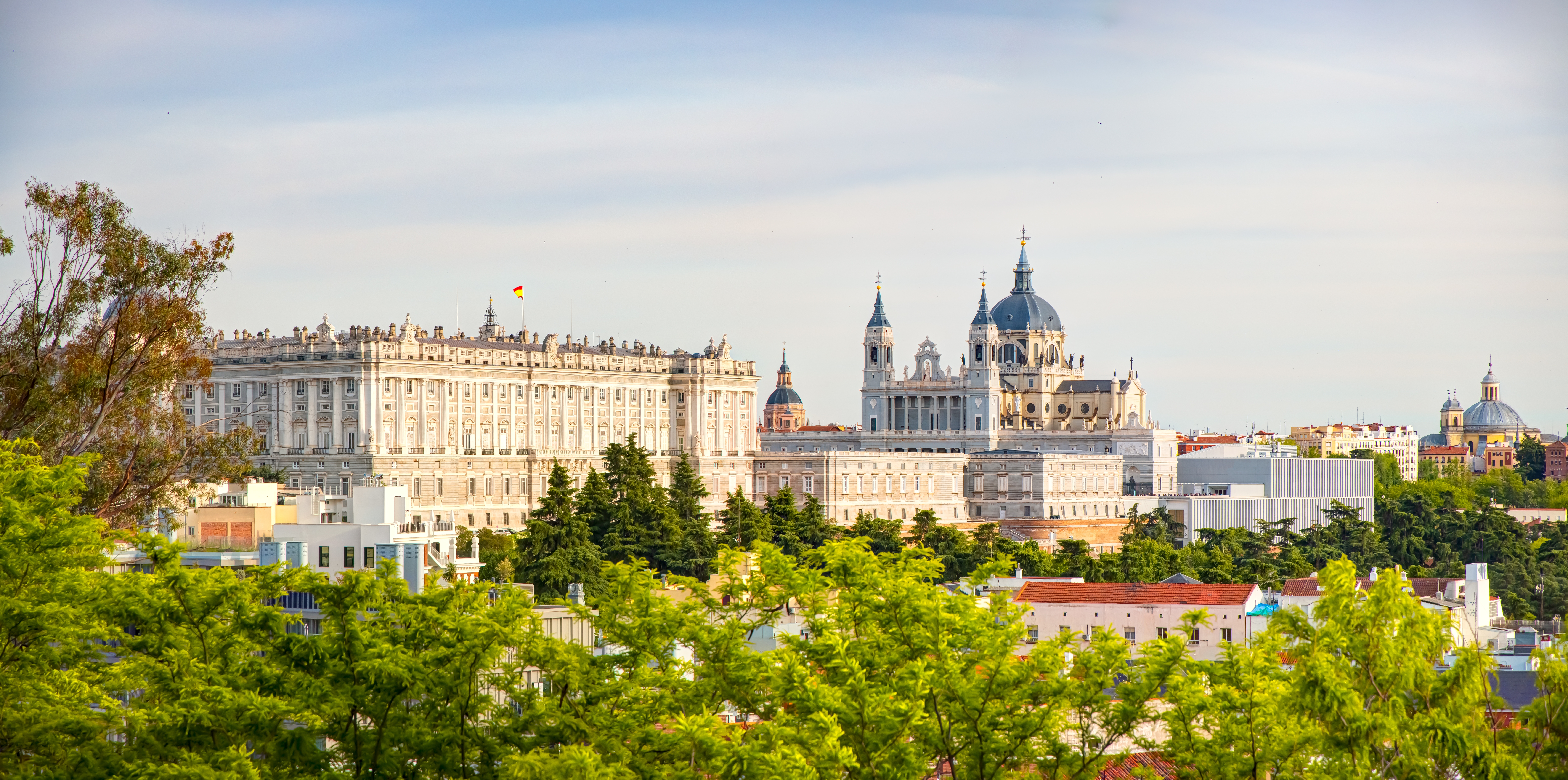 Betagende udsigt over Madrids skyline med den majestætiske Santa Maria la Real de La Almudena Katedral og det Kongelige Palads, to historiske vartegn i Spaniens hovedstad