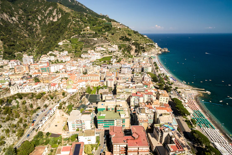 Luftfoto af den charmerende by Maiori på Amalfikysten i Italien med farverige bygninger ned ad grønne bjergsider til det turkisblå Middelhav