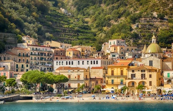 Malerisk udsigt over Maiori ved Amalfikysten med farverige bygninger, blåt Middelhav og karakteristiske terrasserede klipper