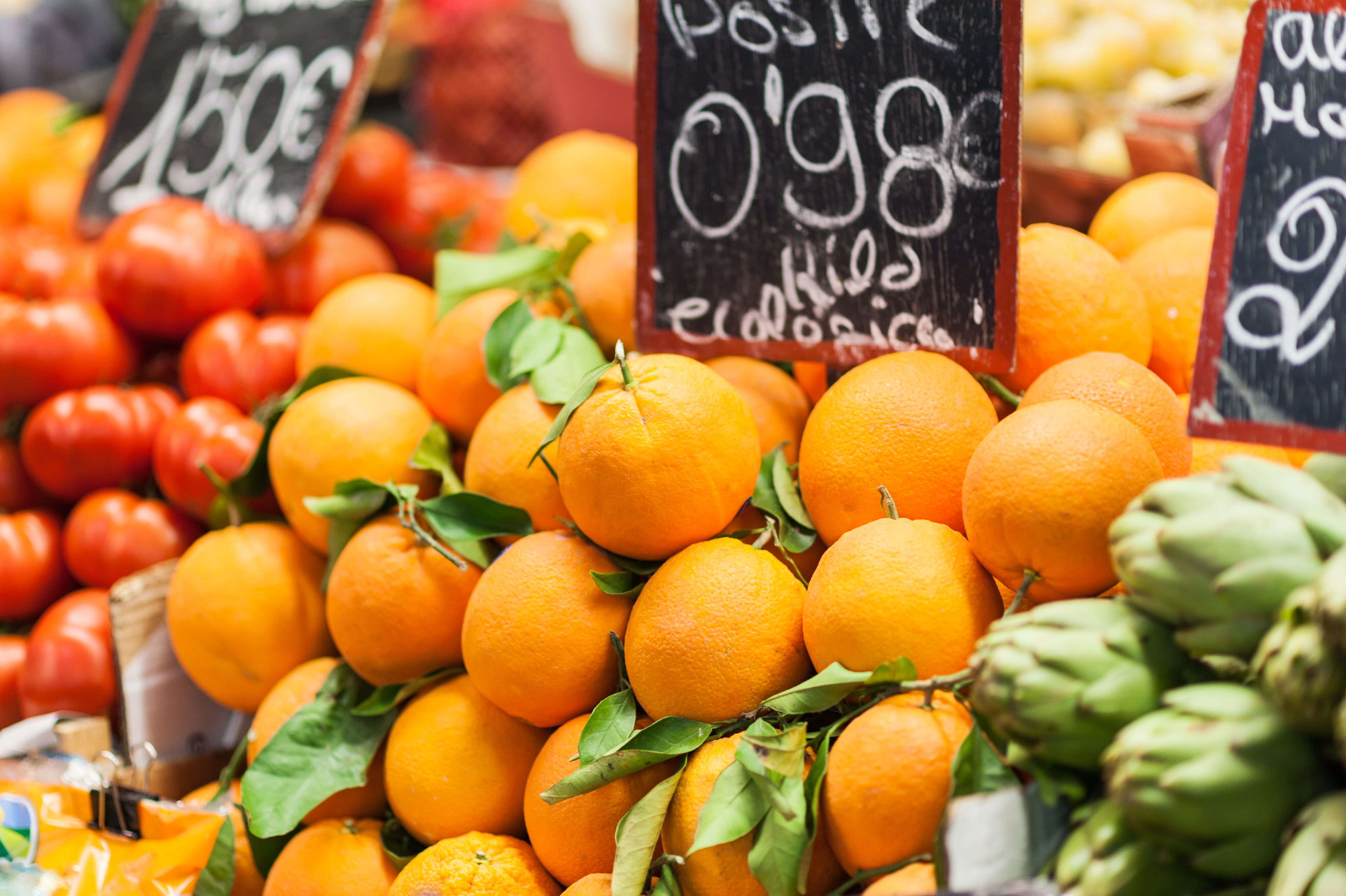 Friske spanske appelsiner med grønne blade udstillet til salg på et traditionelt frugtmarked i Malaga, Andalusien