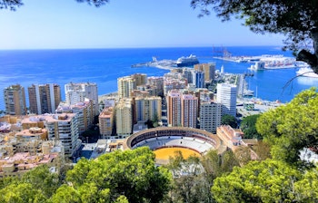Luftfoto af Málaga by med skyskrabere og havn.