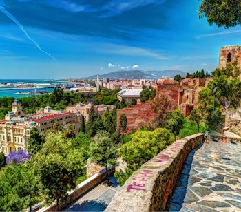 Betagende luftudsigt over Malaga fra Gibralfaro-borgen med den historiske Alcazaba, den majestætiske katedral og den livlige havn langs Middelhavets kyst