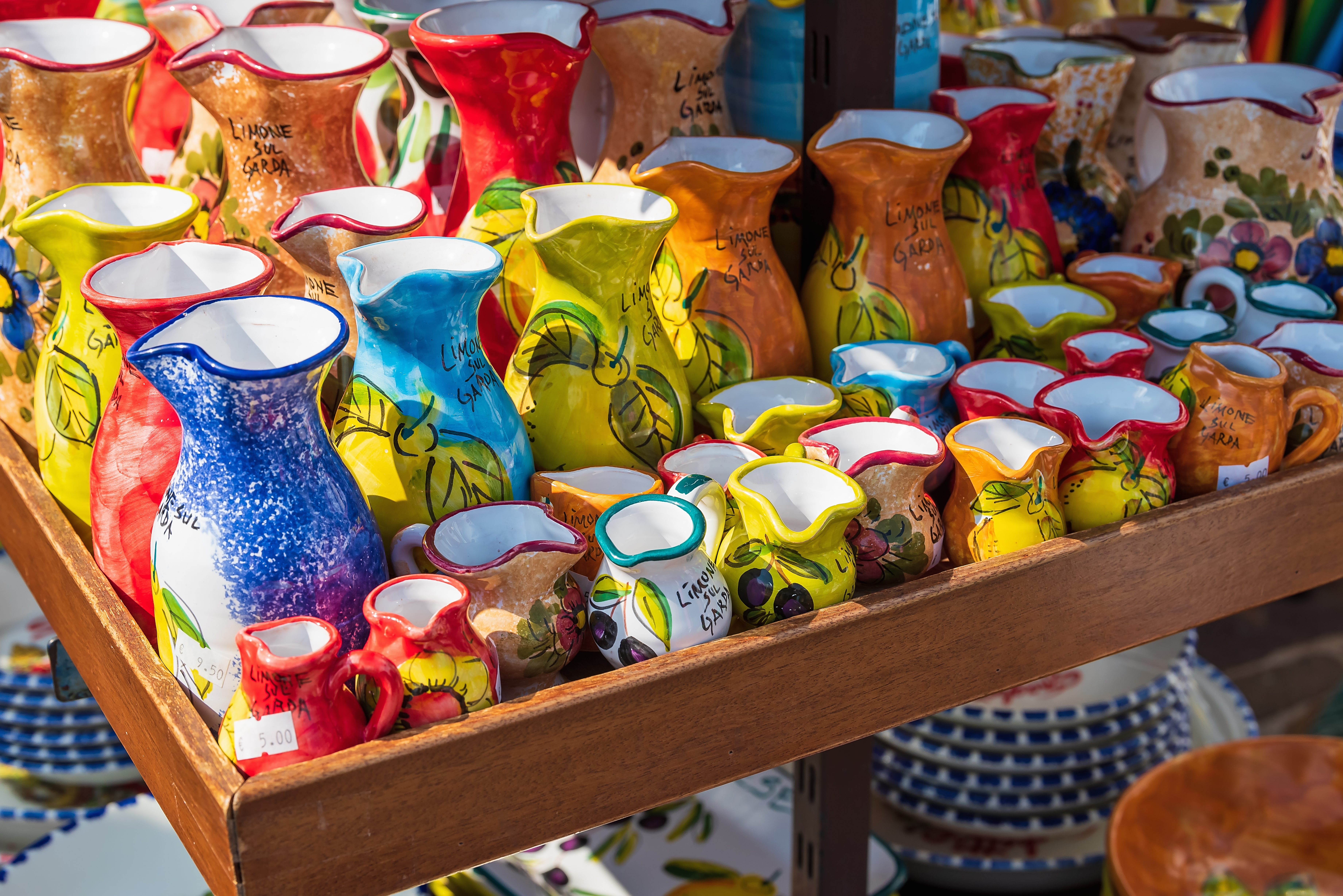 Traditionel italiensk delikatessebutik med farverige pølser og skinker hængende fra træfacaden i Malcesine ved Gardasøen