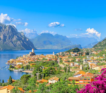 Malerisk udsigt over Malcesine by ved Gardasøen med bjerge og farverige bygninger i Italien