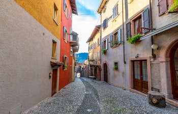 Idyllisk brolagt gade i den historiske by Malcesine ved Gardasøen med traditionelle italienske bygninger i varme farver og træskodder