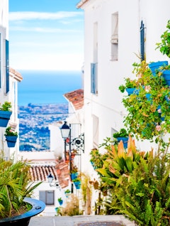 Malerisk gade i Mijas med blomsterkrukker på facaderne, Andalusisk hvid landsby, Costa del Sol, Sydspanien.
