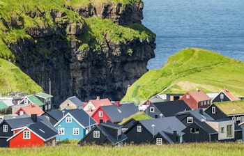 Idyllisk udsigt over den farverige landsby Gjógv med grønne bjerge på Færøerne