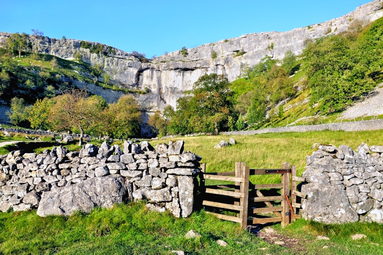 Imponerende kalkstensklipper ved Malham Cove i Yorkshire Dales nationalpark, England med smuk udsigt over det engelske landskab