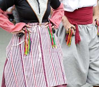 Farverige folkedansere i traditionelle mallorcanske dragter optræder ved en kulturfestival i Palma