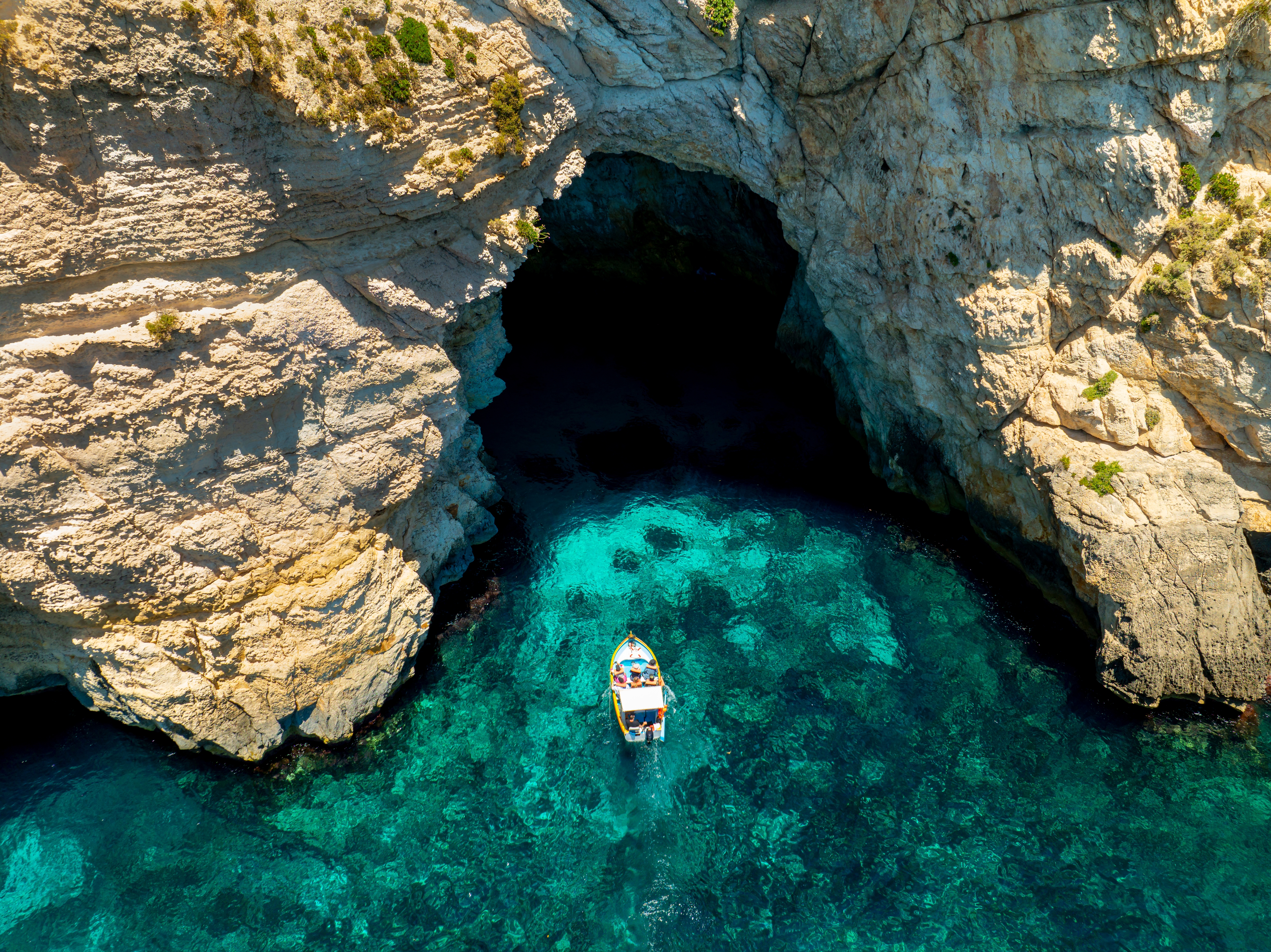 Spektakulær blå grotte på Malta med krystalklart turkisblåt vand og båd i naturlig havhule