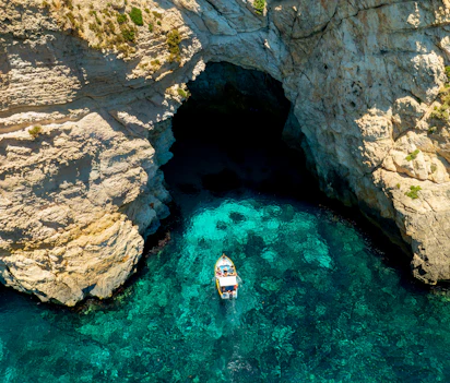 Spektakulær blå grotte på Malta med krystalklart turkisblåt vand og båd i naturlig havhule