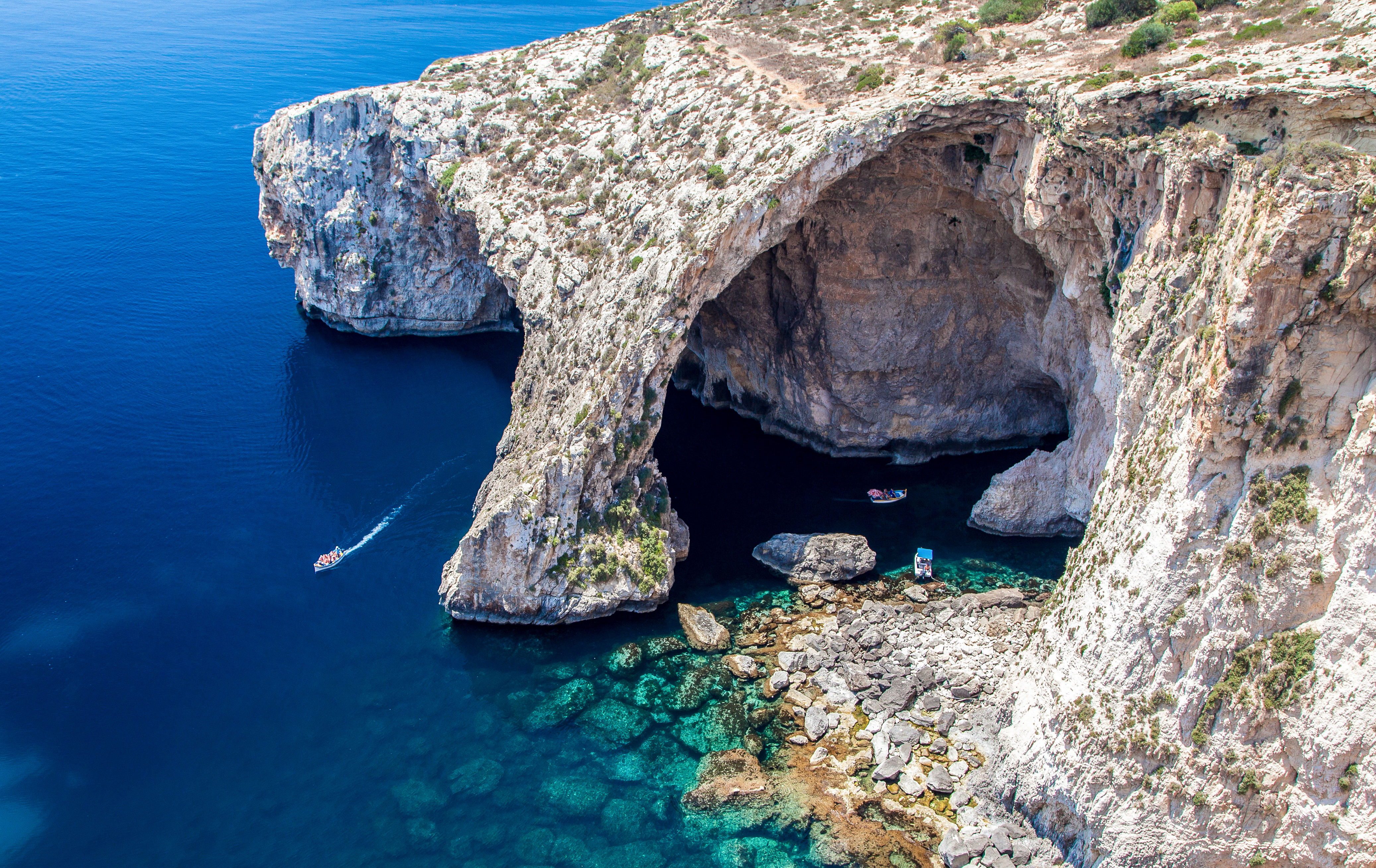Den betagende Blue Grotto havgrotte på Malta med sit intenst azurblå vand, dramatiske kalkstensklipper og naturlige bueformation ved Middelhavets kyst