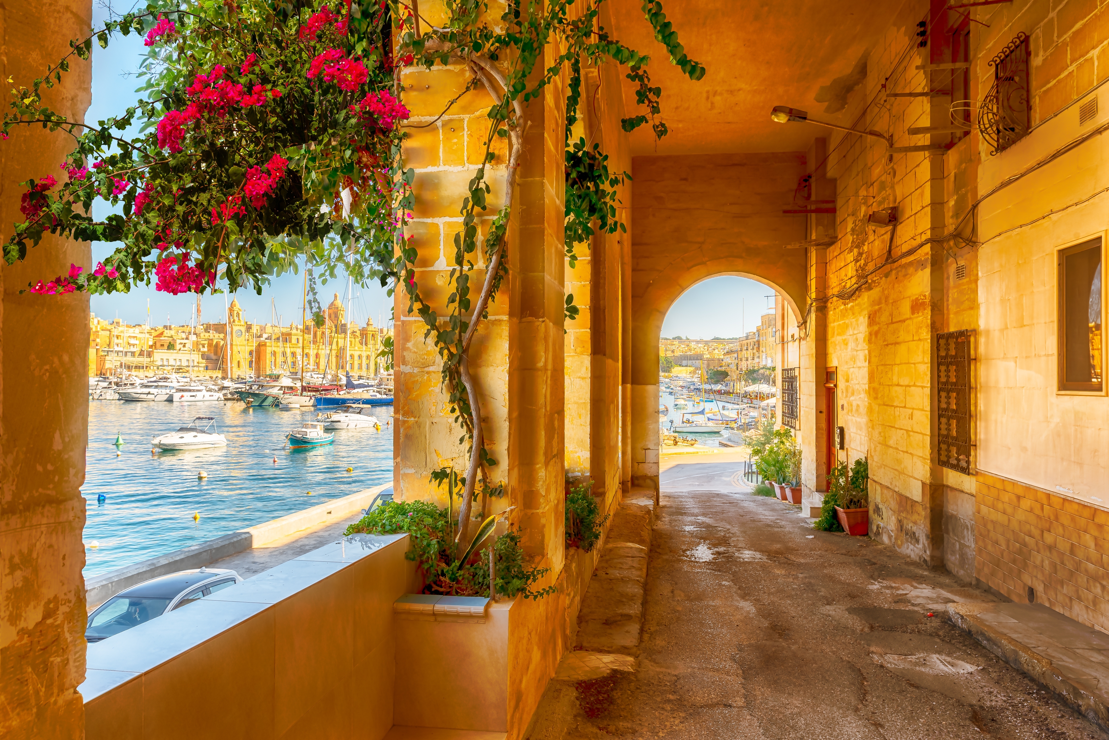 Traditionel maltesisk havneterrasse med farverige blomster og udsigt over Valletta