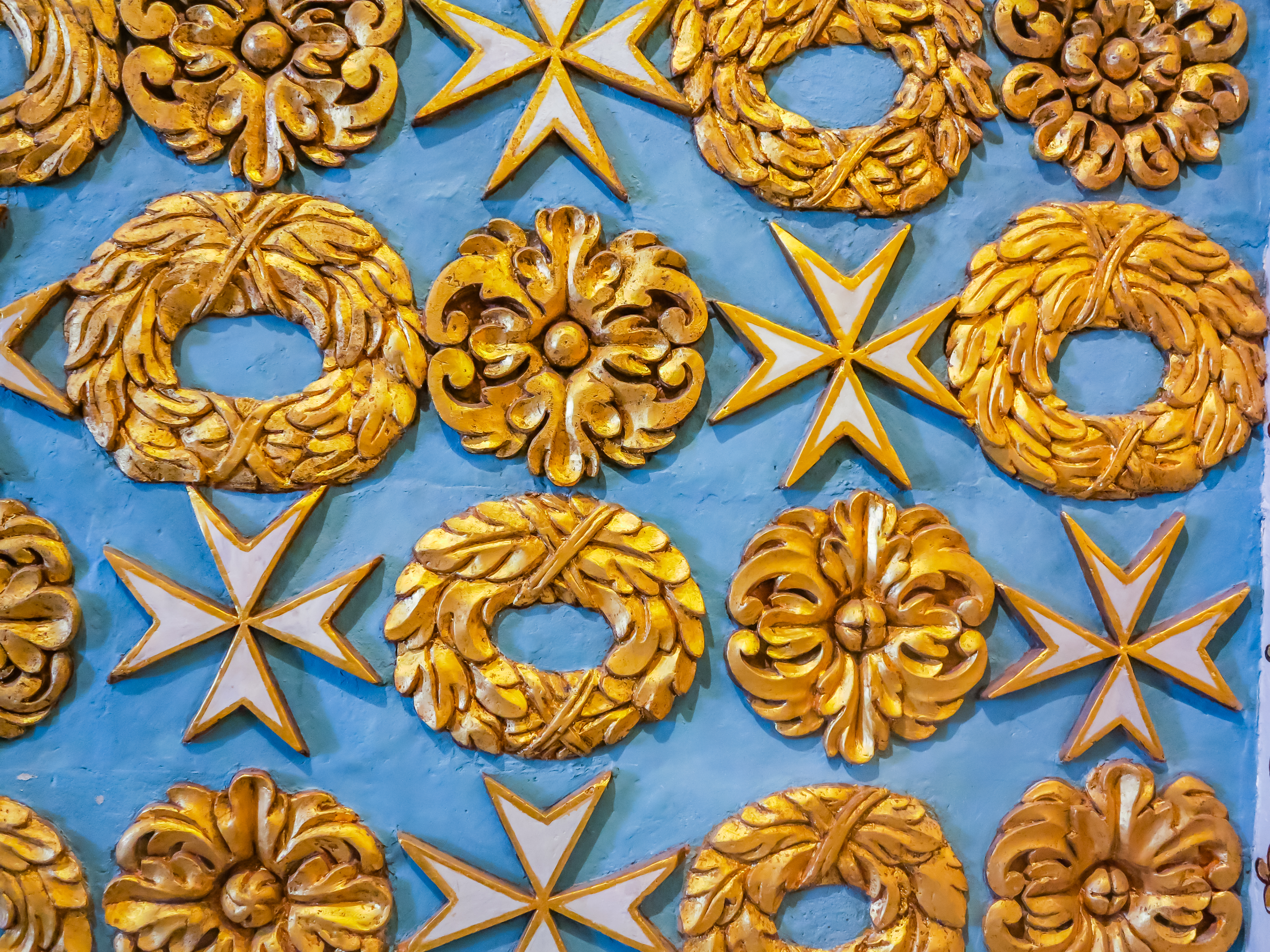 Gyldne Malteserkors og smukke ornamentale dekorationer på blå baggrund i St. John's Co-Cathedral i Valletta, Malta
