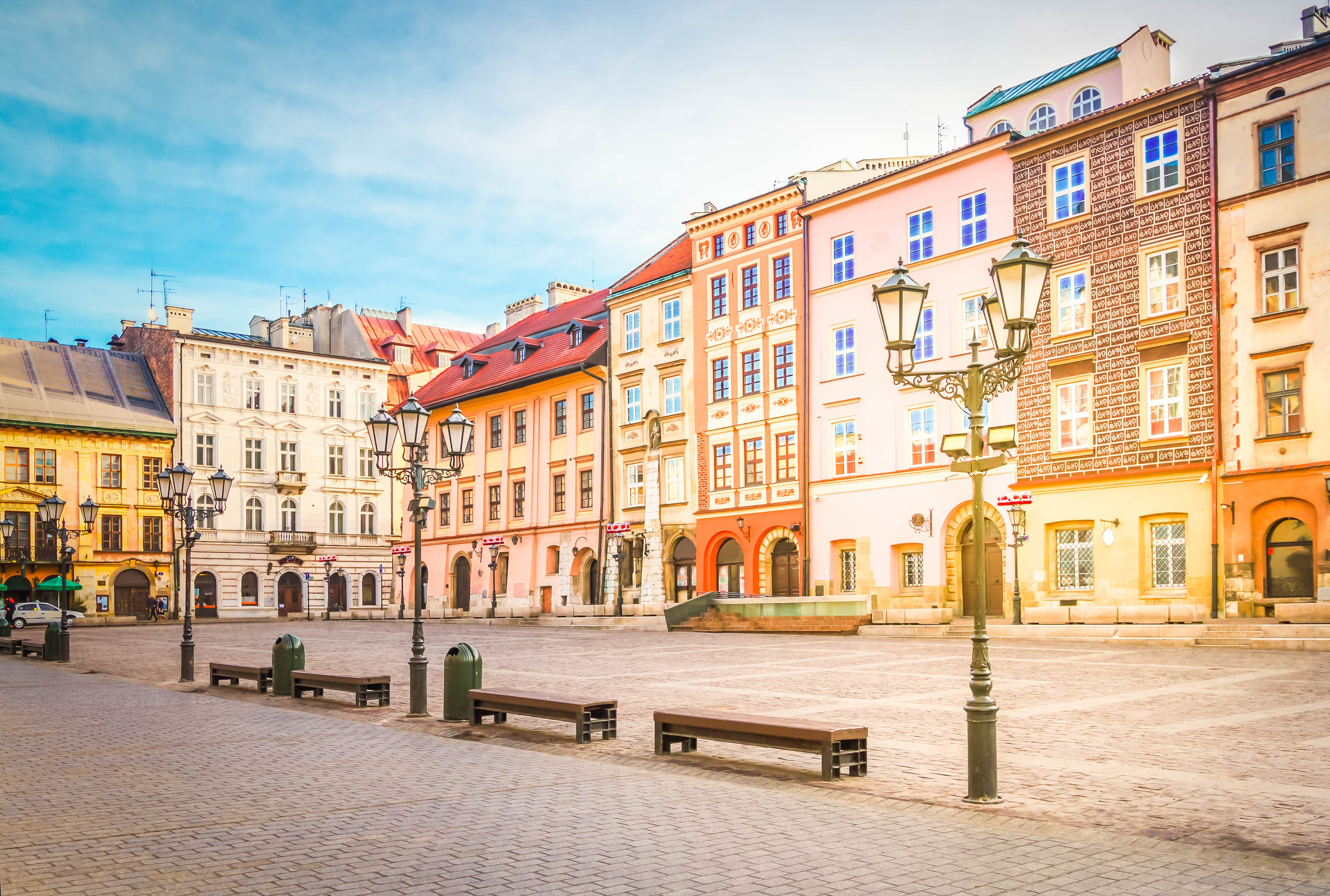Det historiske Maly Rynek torv i Krakows gamle bydel med farverige middelalderlige bygninger og traditionel arkitektur under blå himmel