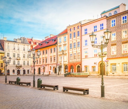 Det historiske Maly Rynek torv i Krakows gamle bydel med farverige middelalderlige bygninger og traditionel arkitektur under blå himmel