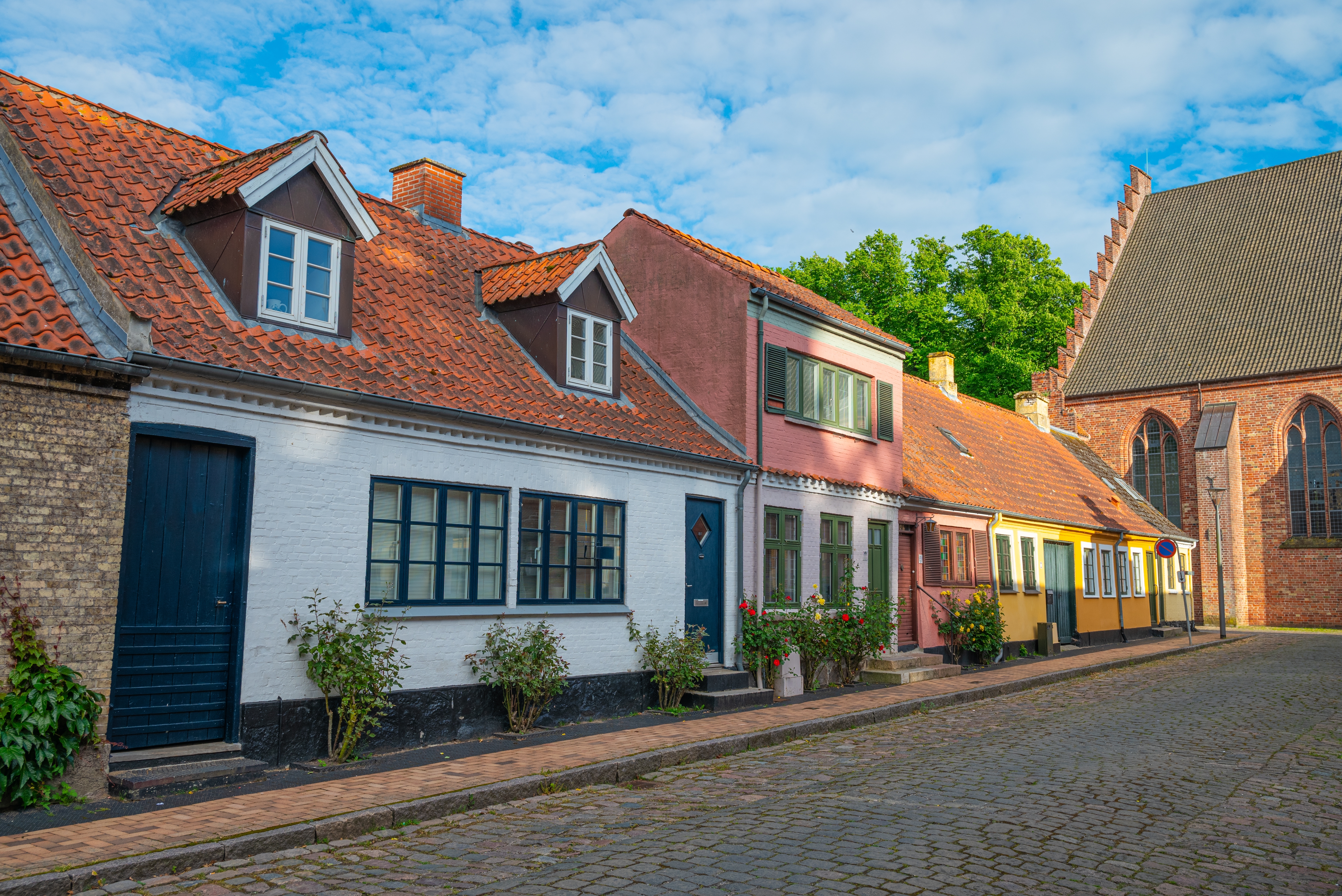 Charmerende brostensgade med farverige danske huse i historiske Maribo på Lolland