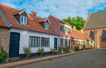 Charmerende brostensgade med farverige danske huse i historiske Maribo på Lolland