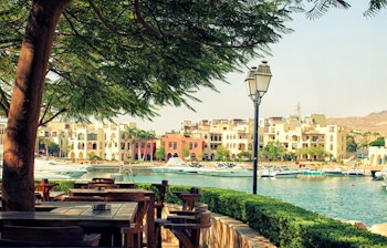 Smuk marina i Aqaba, Jordan med luksusyachter ved kajen, restauranter langs vandkanten og det klare blå vand fra Røde Hav