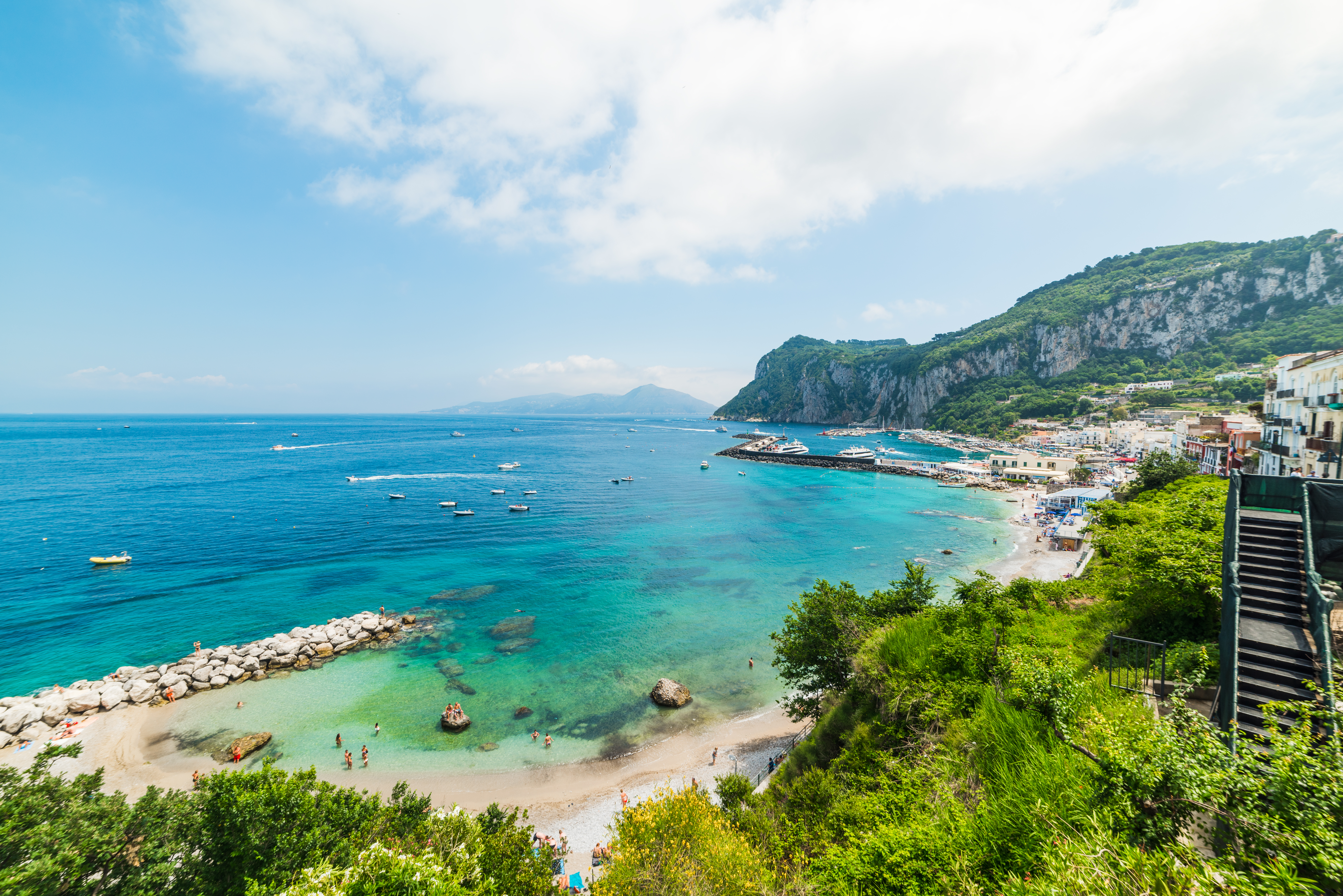 Den berømte Marina Grande strand på Capri med turkisblåt hav og farverige bygninger langs kysten i Campania, Italien