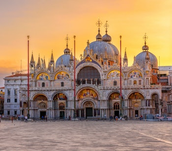 Markuskirken og Markuspladsen i Venedig ved solopgang med det ikoniske klokketårn og historiske arkitektur