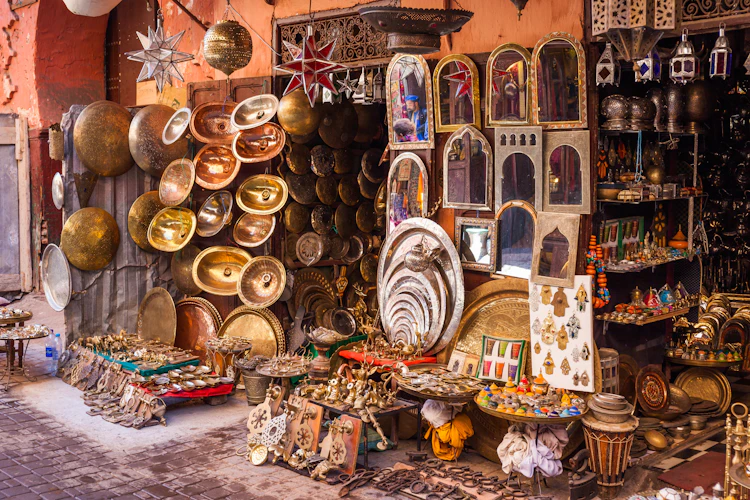 Autentisk marokkansk markedsbod med håndlavede kobbertallerkener, messingskåle og traditionelle souvenirs i Marrakech