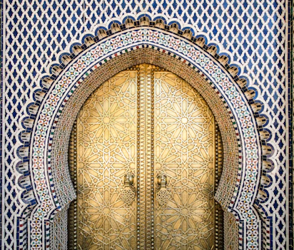 Traditionel marokkansk paladsdør med islamiske mønstre og mosaikfliser i Fez medina