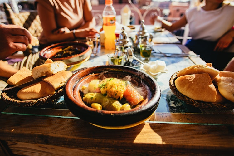 Traditionel marokkansk tajine ret med grøntsager og brød serveret på restaurant i Marrakech