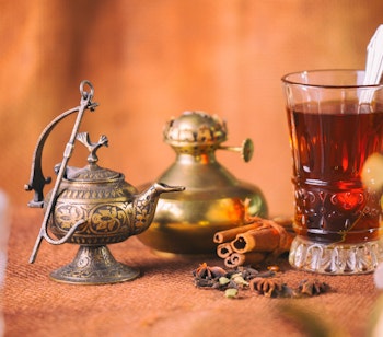 Traditionel marokkansk te-ceremoni fra Tanger med sølvkande, dekorative glas, friske mintblade og citron på træbakke