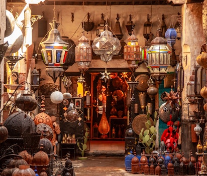 Farverig butik med traditionelle marokkanske lamper og lanterner med dekorativt metalarbejde og farvet glas i den livlige souk-markedsplads i Marrakech, Marokko
