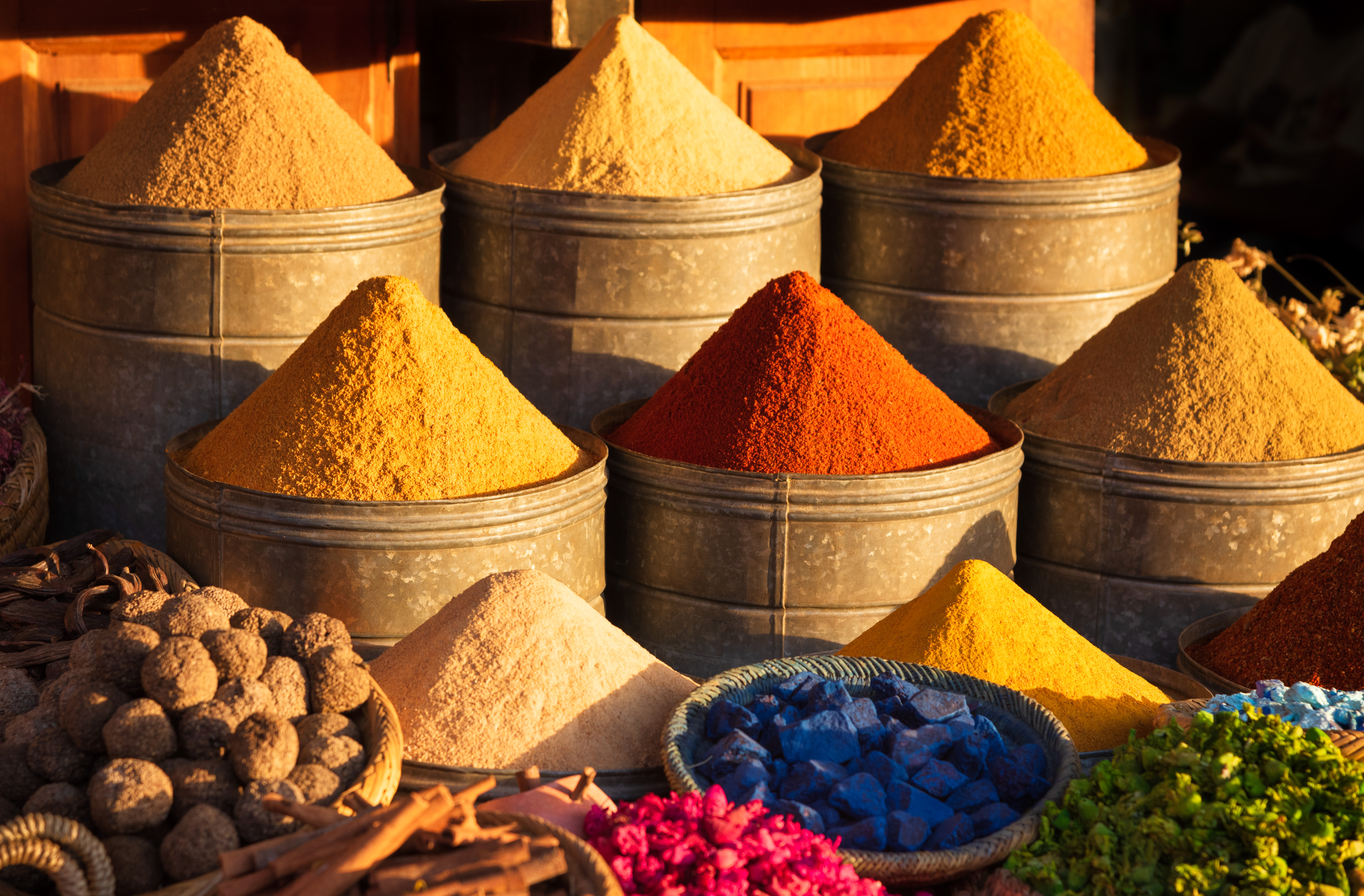 Farverige pyramider af krydderier i nuancer af rød, gul og orange udstillet på det traditionelle souk-marked i Marrakesh, Marokko