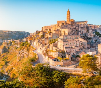 Betagende panoramaudsigt over Matera's historiske grotteboliger badet i gyldent morgenlys ved solopgang i Basilicata-regionen, Syditalien