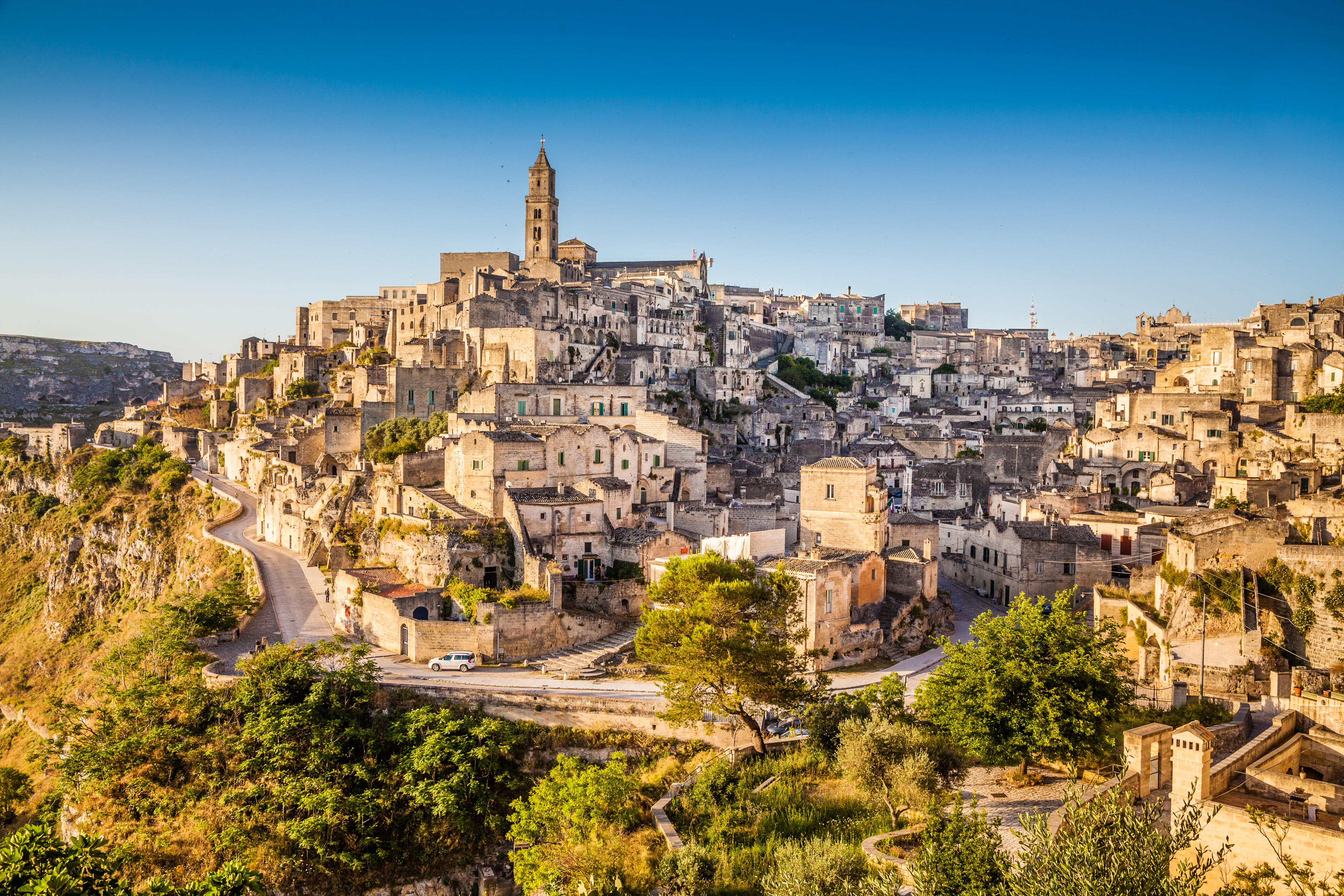 Den historiske grottebebyggelse Sassi di Matera badet i gyldent morgenlys ved solopgang i Basilicata-regionen, Syditalien