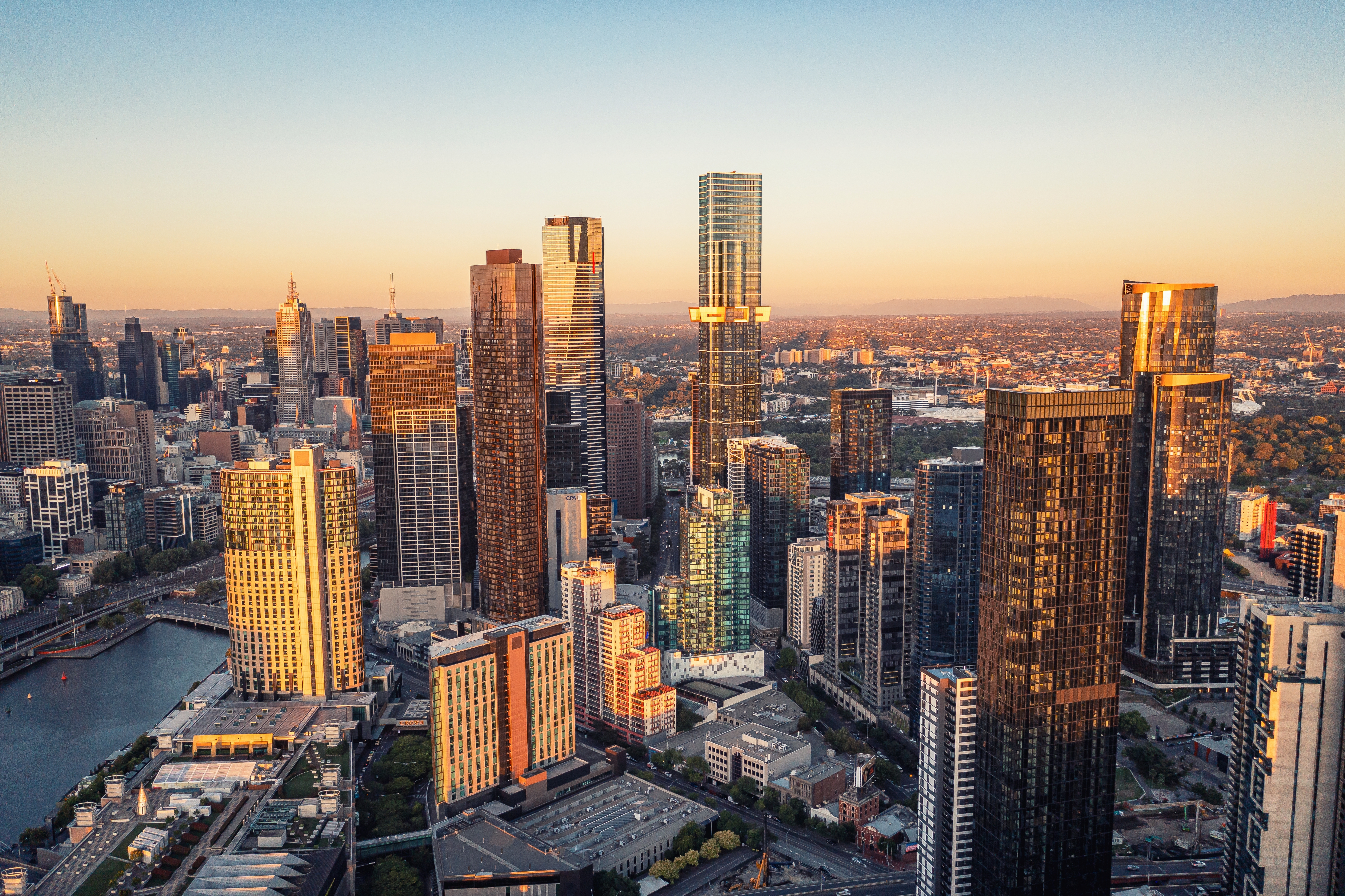 Melbourne byskyline ved solnedgang med moderne skyskrabere og Yarra floden