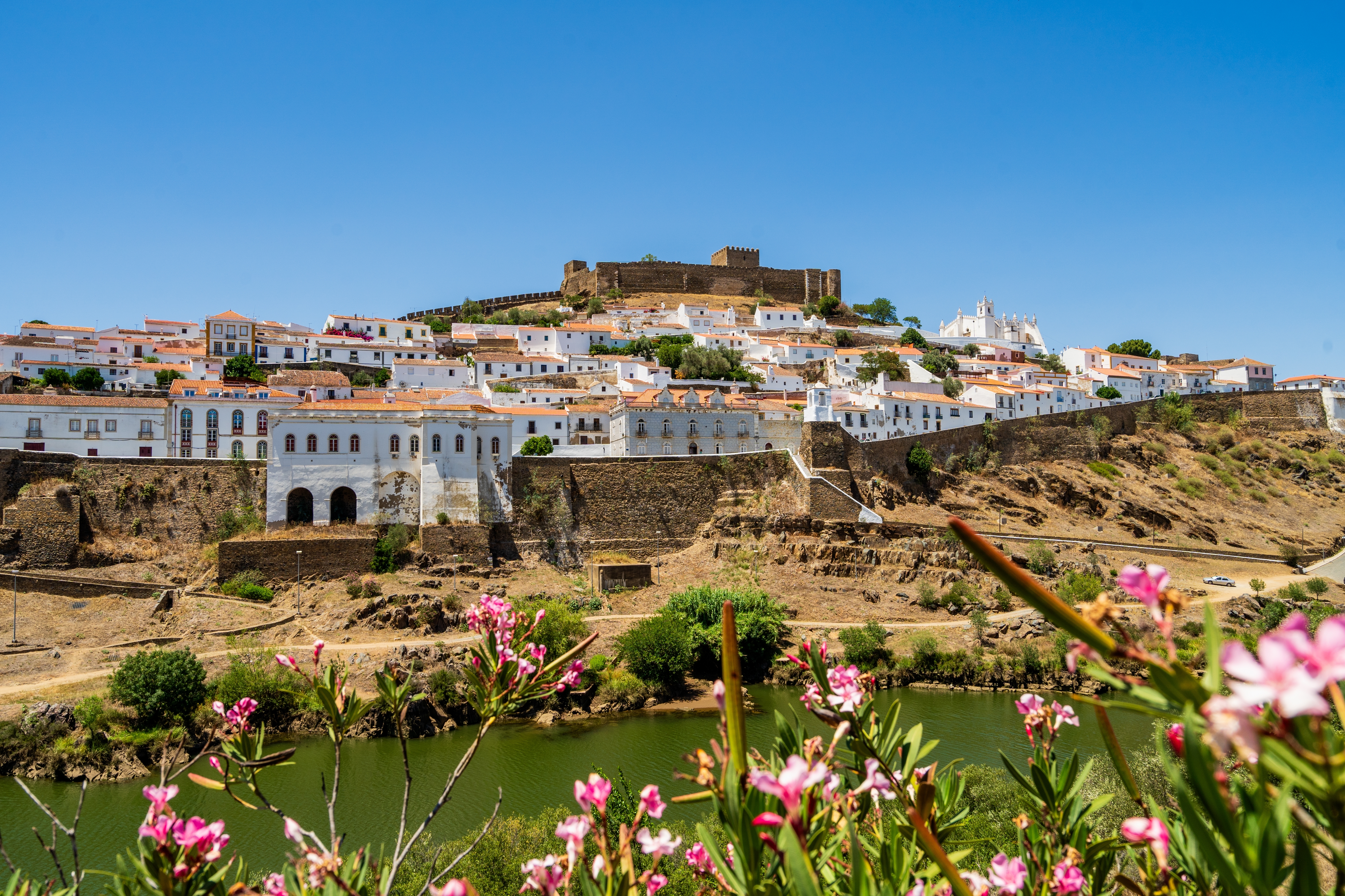 Historisk hvid landsby Mertola med gammelt slot ved Guadiana floden i Portugal