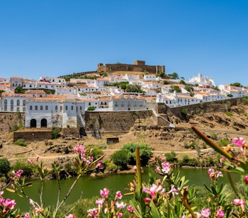 Historisk hvid landsby Mertola med gammelt slot ved Guadiana floden i Portugal