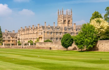 Det historiske Merton College med sin imponerende middelalderarkitektur og karakteristiske tårn omgivet af velholdte grønne plæner på Oxford Universitet i England