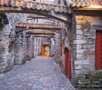 Historisk St. Katharinas passage med stenbuegange og røde døre i Tallinn, Estland