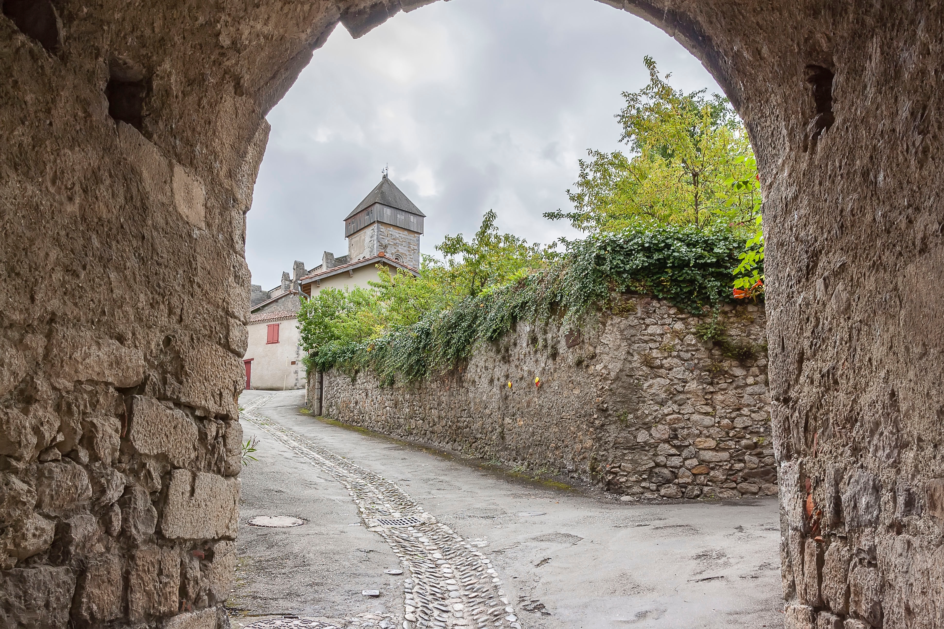 Charmerende middelaldergade med historisk stentårn i den franske bjerglandsby Saint-Bertrand-de-Comminges