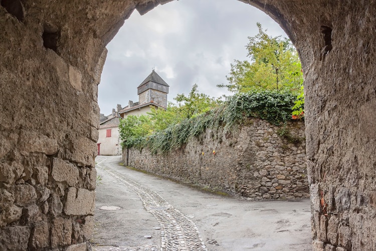 Charmerende middelaldergade med historisk stentårn i den franske bjerglandsby Saint-Bertrand-de-Comminges