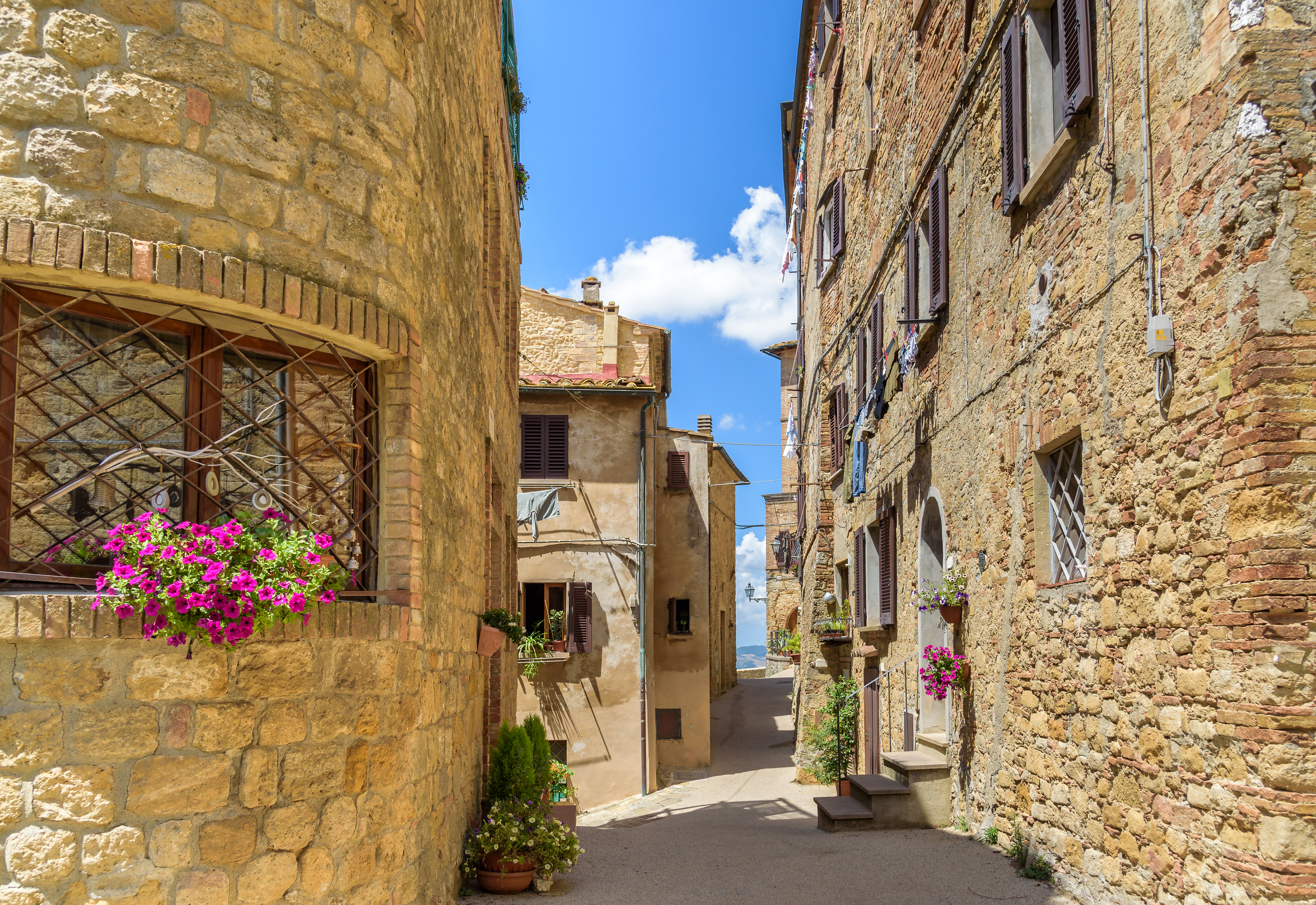 Charmerende smal gade med historiske stenhuse i den middelalderlige by Volterra, Toscana - en af perlerne på vores rejse