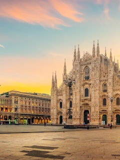 Den majestætiske Milano Domkirke (Duomo di Milano) med sine gotiske spir oplyst i det tidlige morgenlys på Piazza del Duomo, et af Italiens mest ikoniske bygningsværker