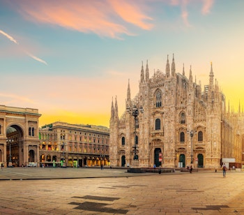 Den majestætiske Milano Domkirke (Duomo di Milano) med sine gotiske spir oplyst i det tidlige morgenlys på Piazza del Duomo, et af Italiens mest ikoniske bygningsværker