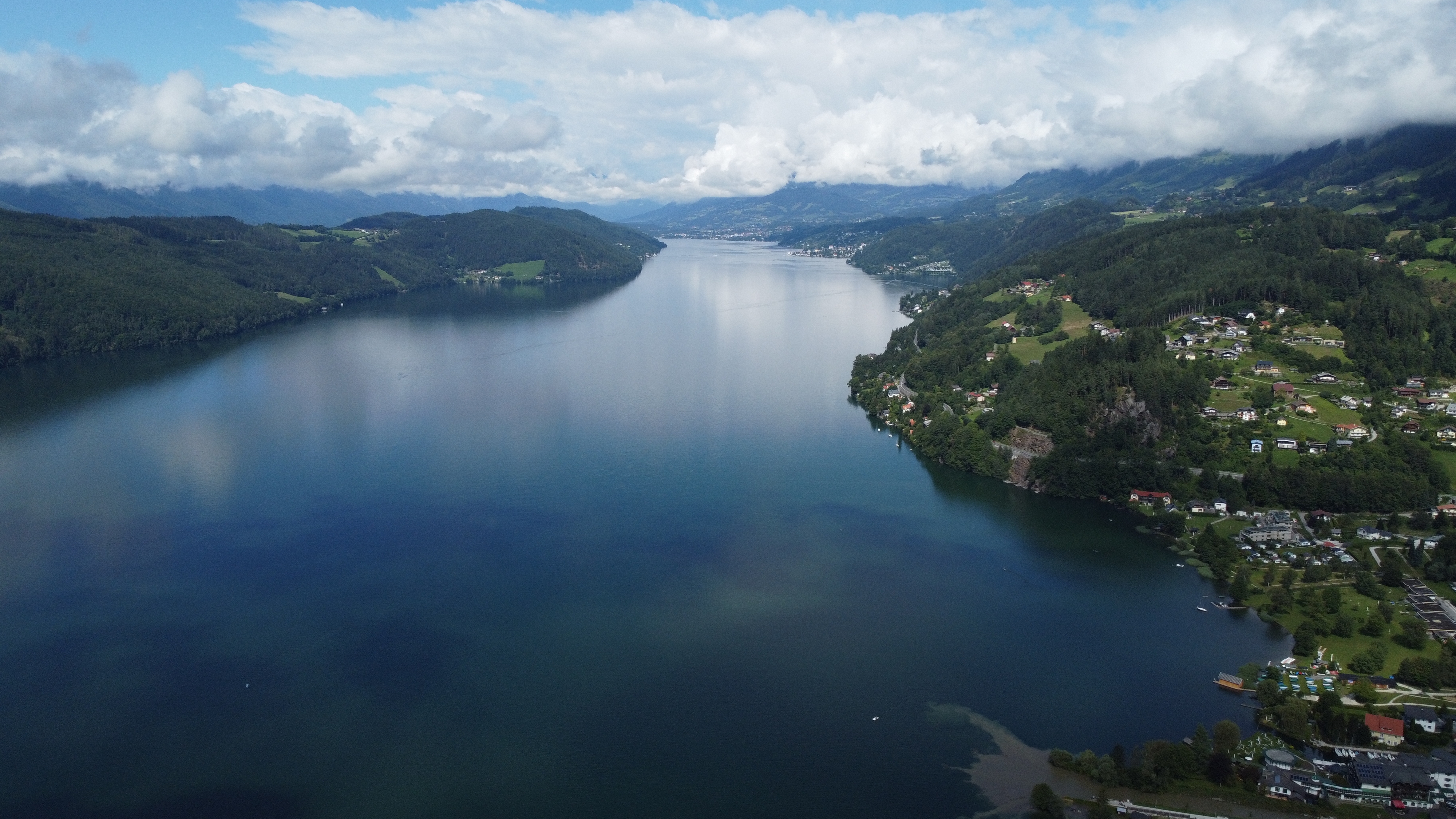 Luftfoto af det smukke Millstätter See omgivet af grønne bjerge og østrigske landsbyer