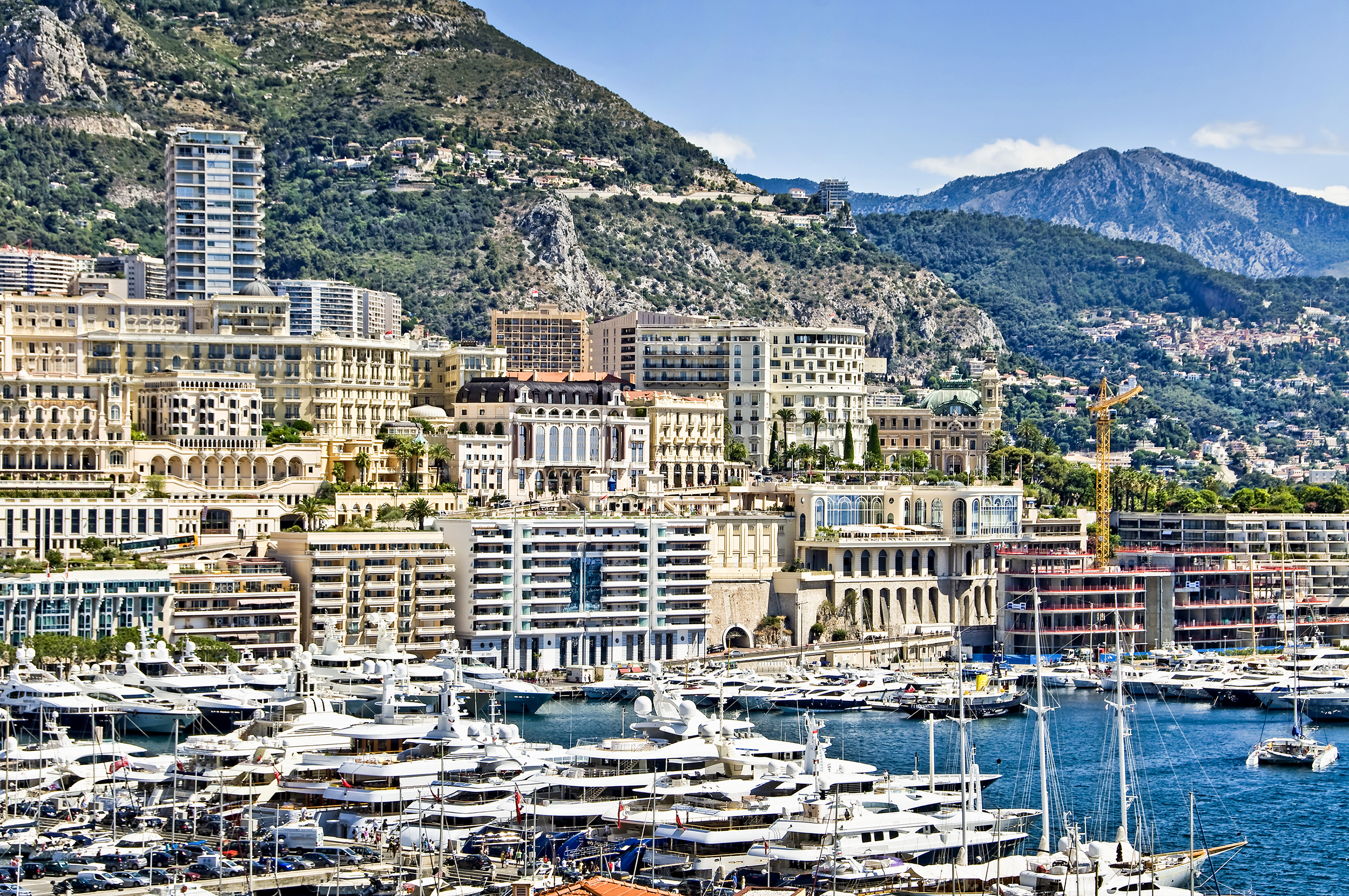 Panoramaudsigt over Monacos luksuriøse havn med yachter og bygninger langs den franske riviera