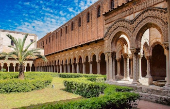 Den historiske klostergård med byzantinske søjler i Monreale-katedralen på Sicilien - et UNESCO verdensarvssted