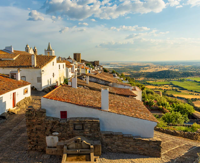 Traditionelle hvide huse med røde tagsten i den middelalderlige by Monsaraz, Portugal, med udsigt over landskabet