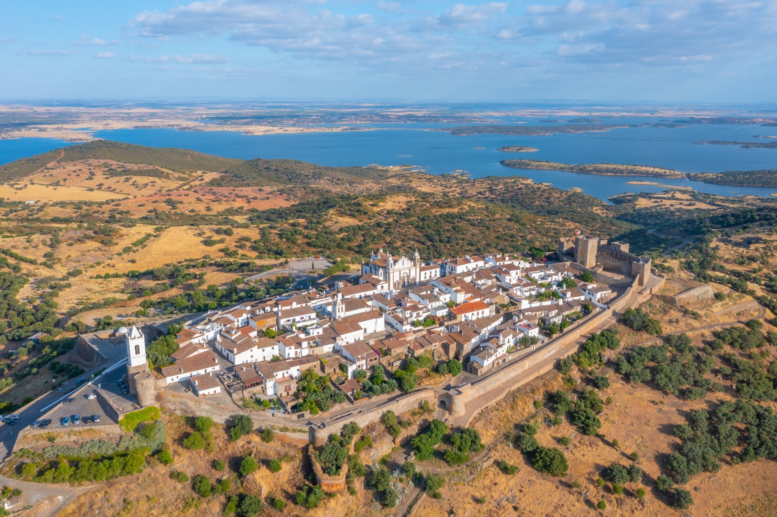 Luftfoto af den middelalderlige landsby Monsaraz med hvide huse omgivet af fæstningsmure i Alentejo, Portugal